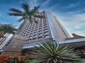 Un edificio hotelero alto de diseño moderno, que cuenta con una recepción y un restaurante.