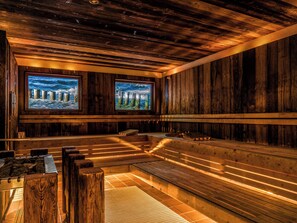 A sauna with wooden walls, benches, and two large windows with ocean scenes. - PLAZA Premium Sylt (Wenningstedt-Braderup)