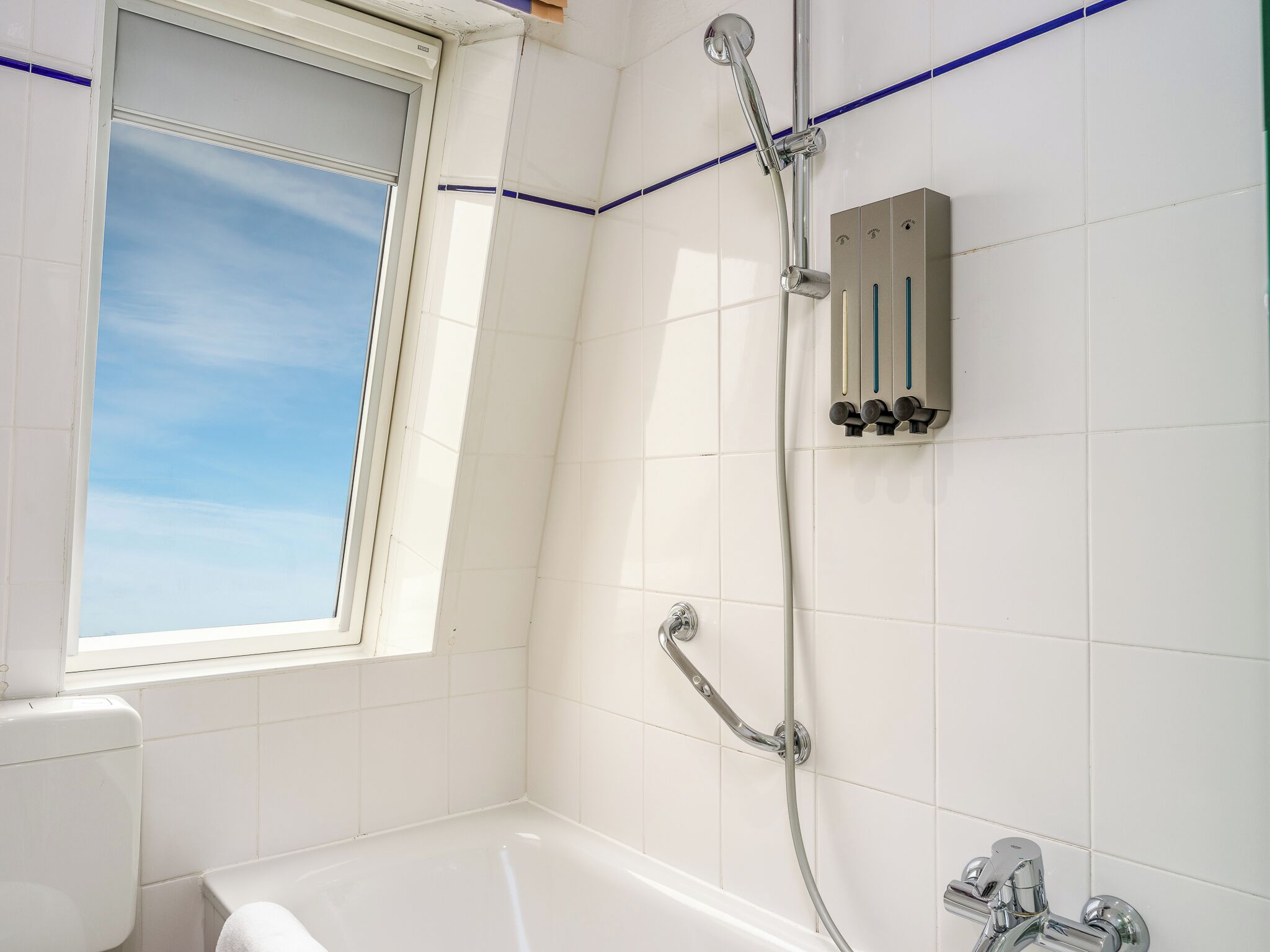 A bathroom with a bathtub, a shower, and a window.