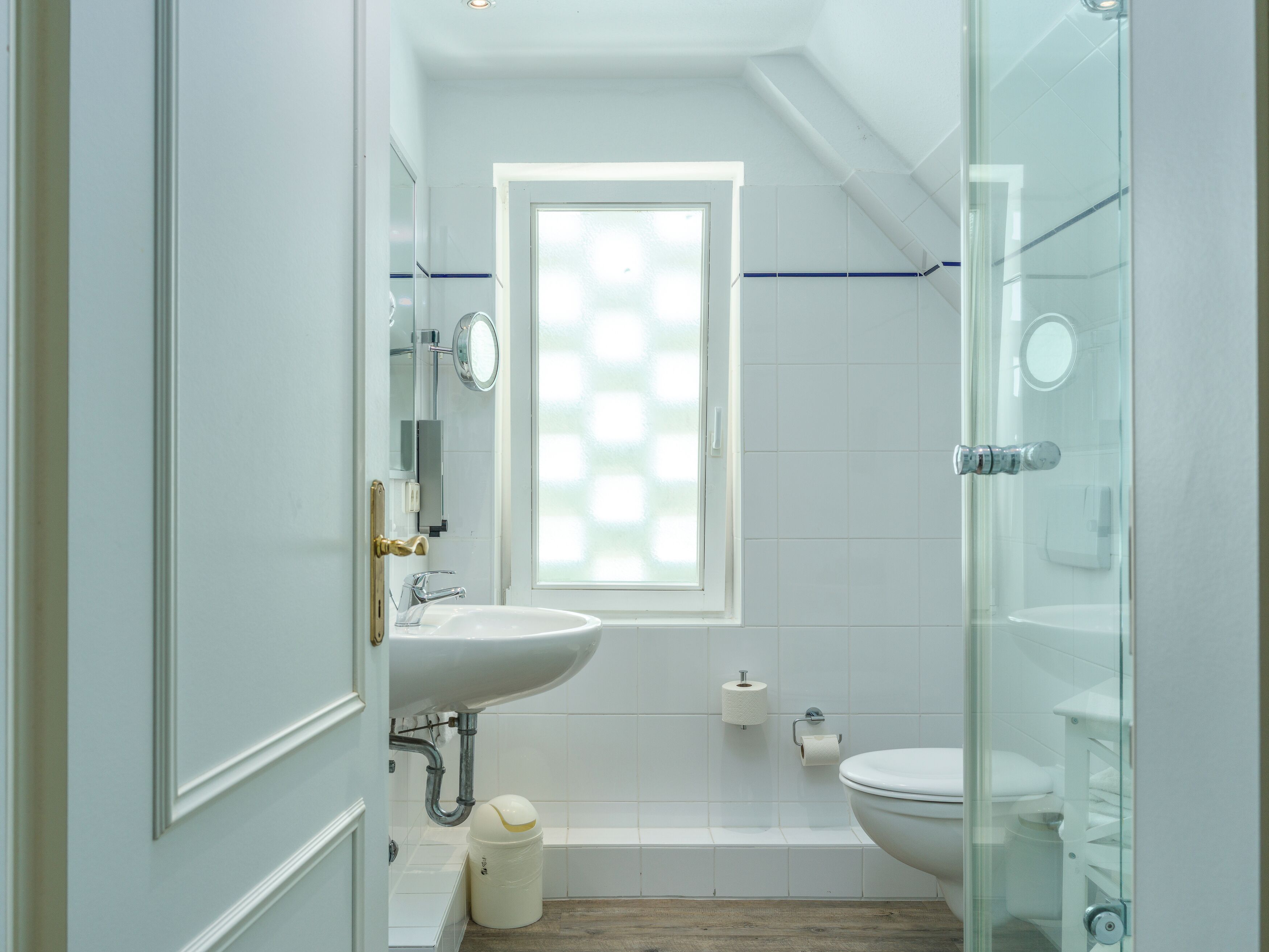 Une salle de bain avec une fenêtre, une baignoire, des toilettes et un lavabo.