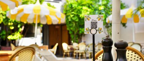 A wooden table with salt and pepper shakers and a QR code menu sign.