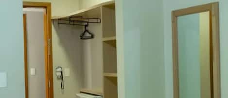 A room with a bed, a wardrobe, and a mirror.