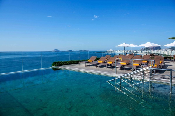 Een buitenzwembad, parasols bij het zwembad en ligstoelen