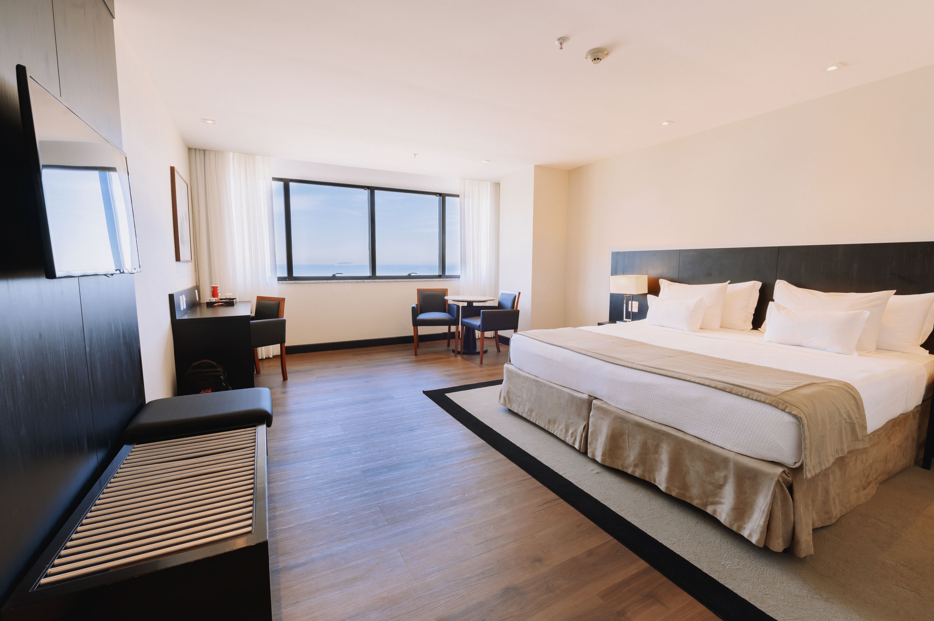 Una habitación de hotel moderna con una cama grande, un escritorio y una silla.