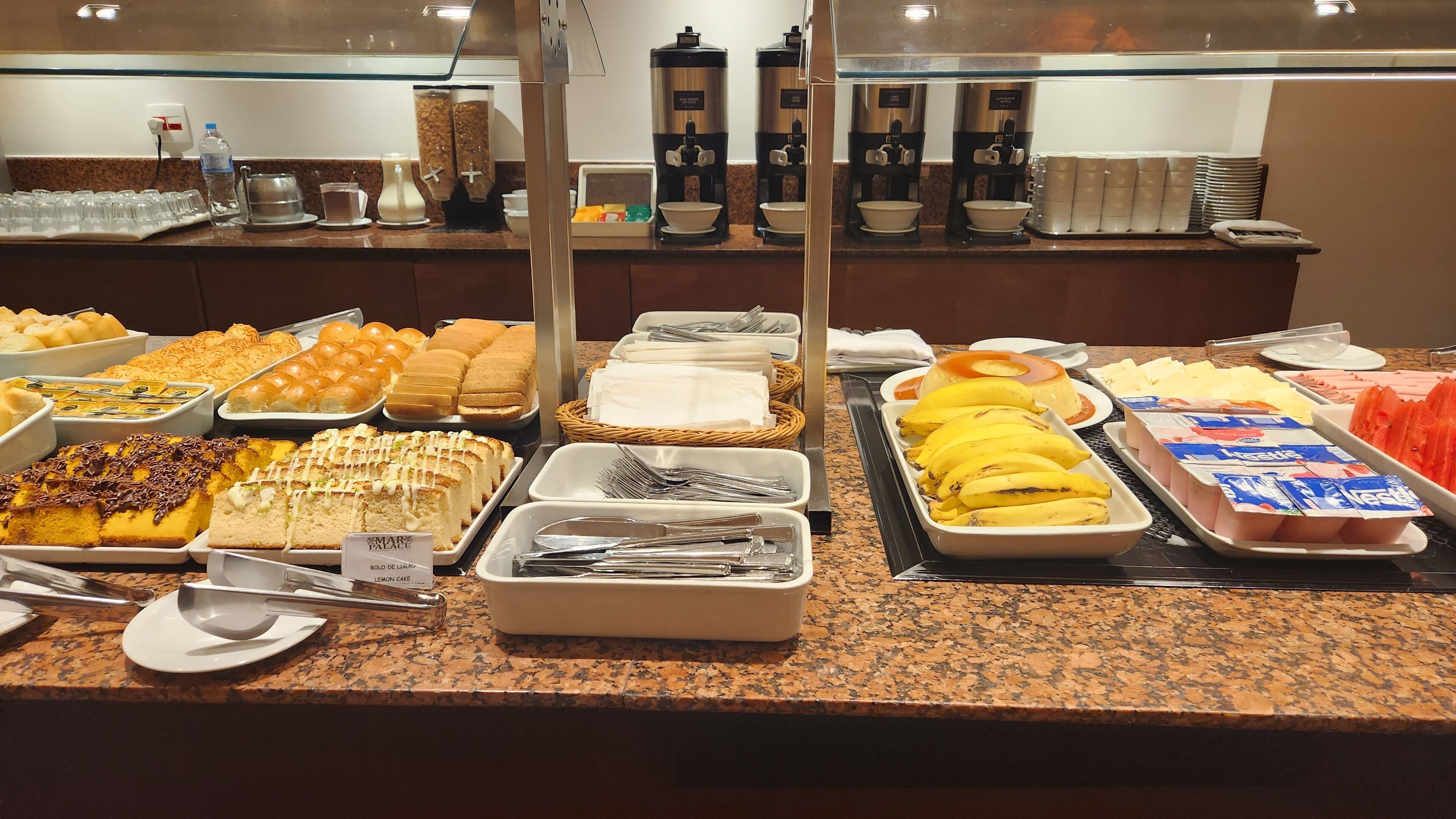 A buffet with various food items and a coffee station.