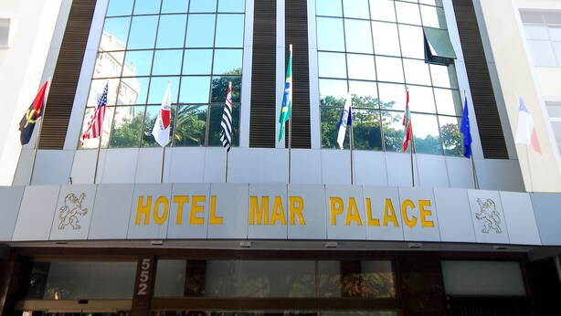 En hög hotellbyggnad med en modern glasfasad och det tydligt synliga namnet ”HOTEL MAR PALACE”.