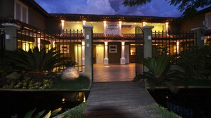A hotel entrance with a tiled roof, a sign reading "Paseados de Búxos", and a gated pathway leading to the entrance. - Pousada dos Buzios (Búzios)