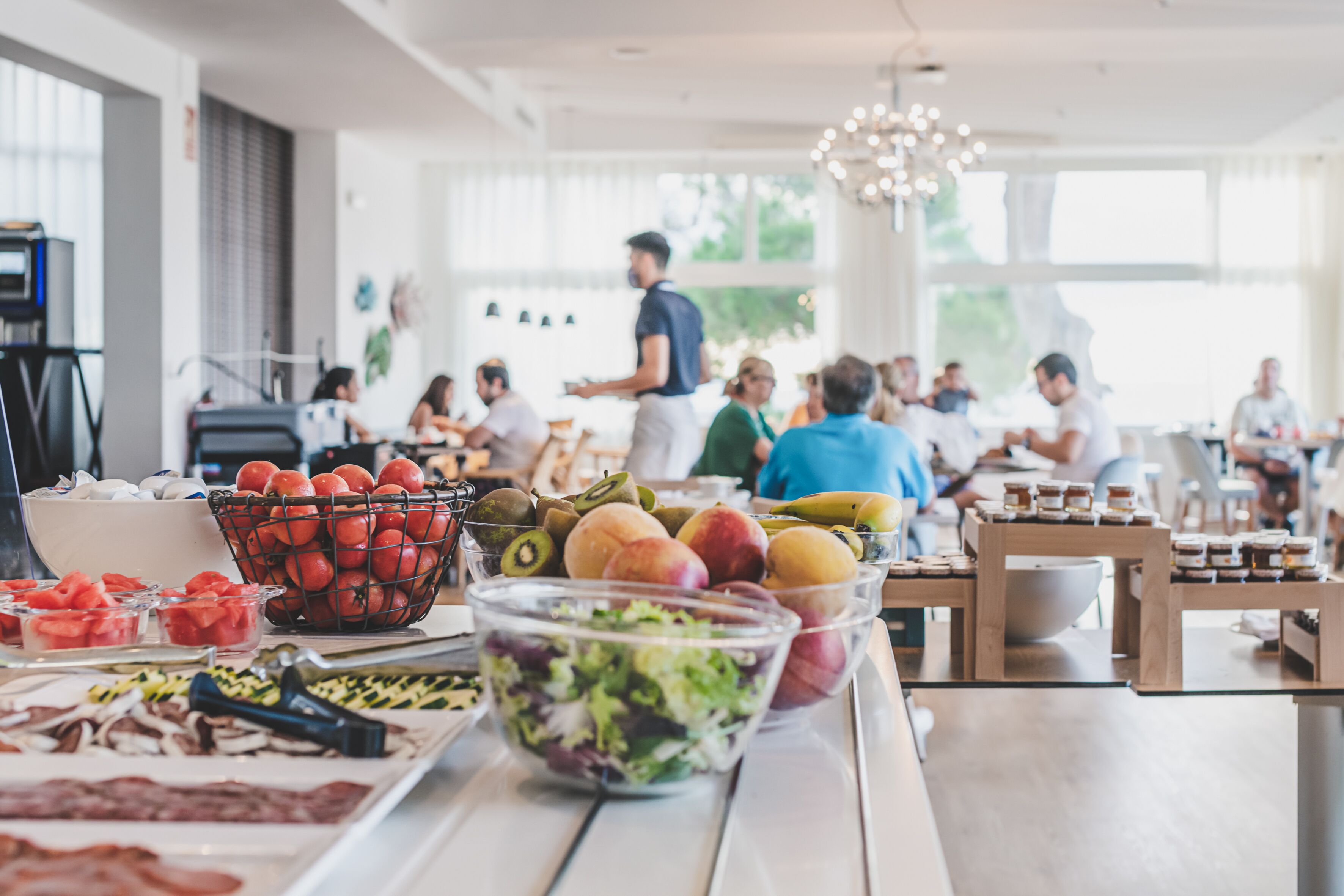 Ein reichhaltiges Buffet mit verschiedenen Speisen und einer Person, die bedient.