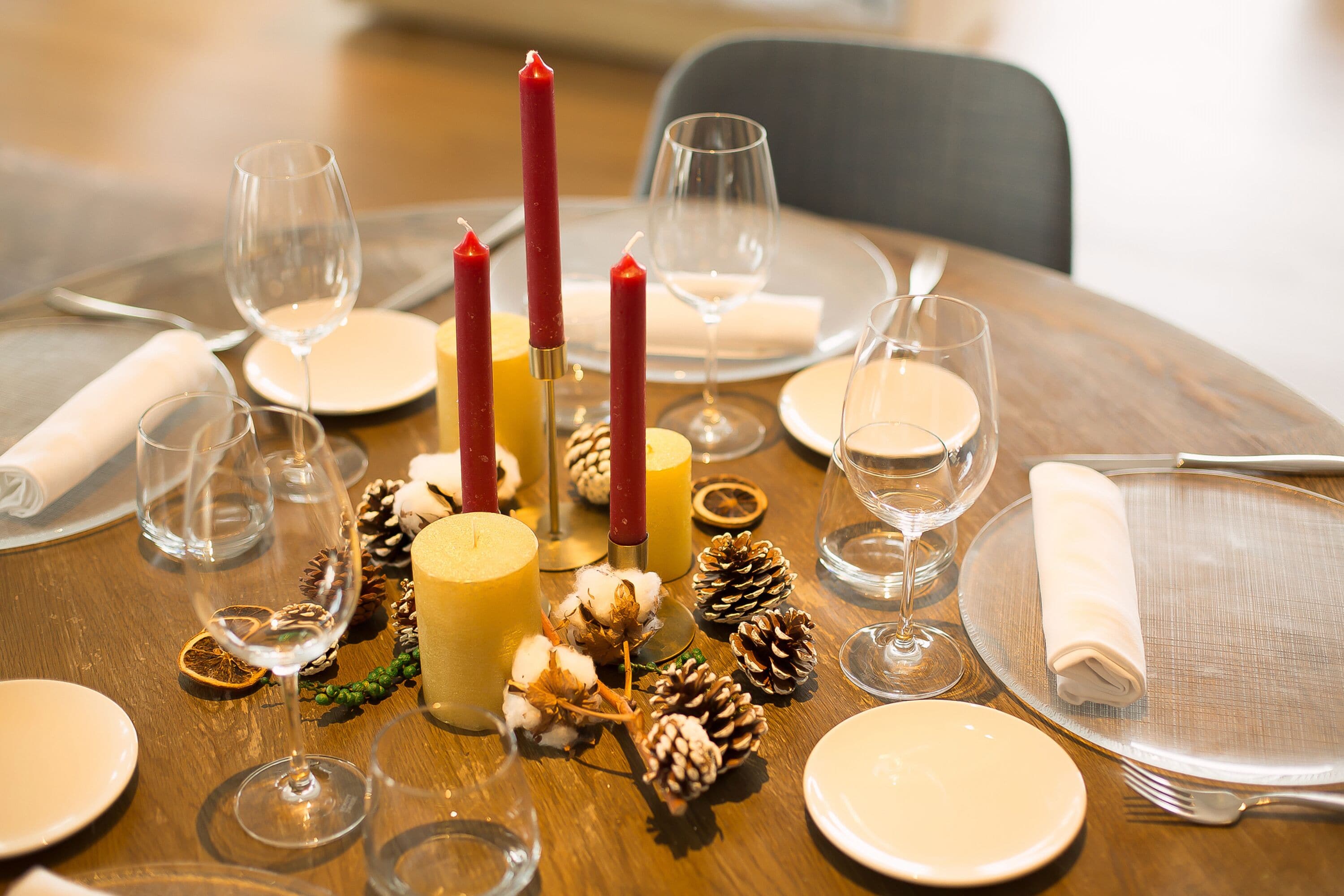 Una mesa puesta para una comida con velas, platos y copas.