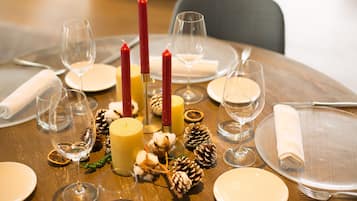 A table set for a meal with candles, plates, and glasses.