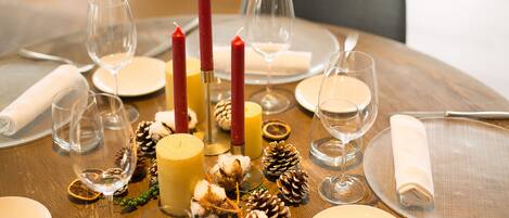 Una mesa puesta para una comida con velas, platos y copas.