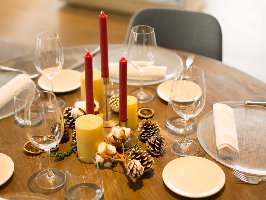 Una mesa puesta para una comida con velas, platos y copas.