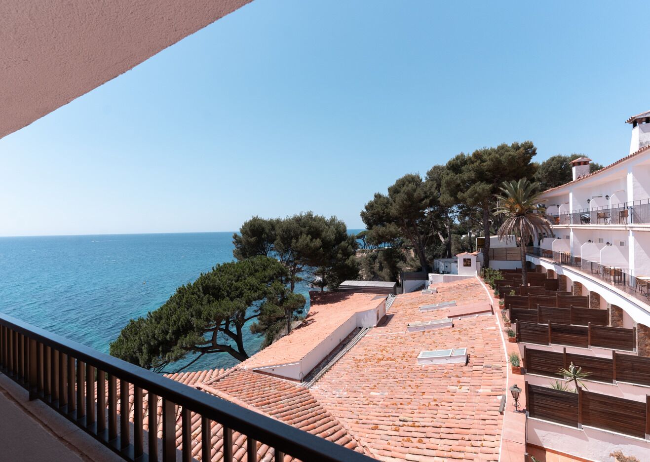 Una terraza con vista al mar, rodeada de árboles y edificios.
