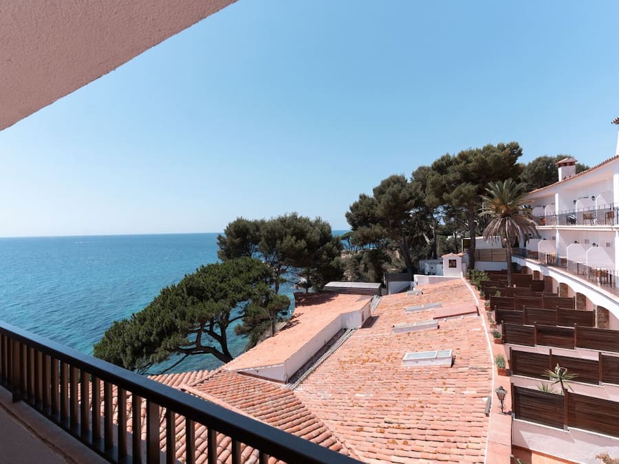 Una terraza con vista al mar, rodeada de árboles y edificios.