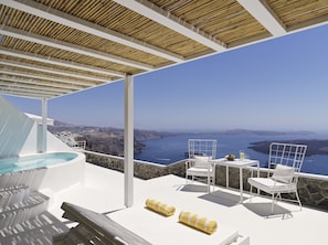A rooftop terrace with a pool, white furniture, and a view of the sea and coastline. - Katikies Chromata Santorini - The Leading Hotels of the World (Santorini)