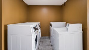 A laundry room with two white front-loading washing machines and a dryer. - Econo Lodge Allentown North (Allentown)