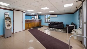 A clean, well-lit lobby with a reception desk, an ATM, a sofa, and a large window. - Econo Lodge Allentown North (Allentown)