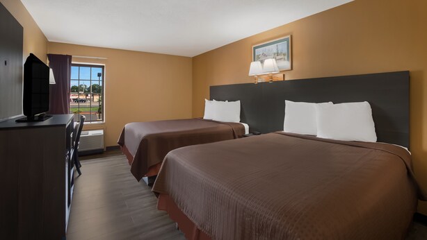 A hotel room with two beds, a desk with a TV, and a window with a view of a parking lot. - Econo Lodge Allentown North (Allentown)