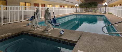 Una piscina interior con socorrista, sillas de descanso y zona vallada.