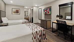 A hotel room with two beds, a desk, a chair, a TV, and a bathroom. - Red Roof Inn & Suites Irving – DFW Airport South  (Irving)