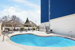 A clear blue swimming pool with lounge chairs and a covered seating area. - Holiday Inn Express & Suites Atlanta - Tucker Northlake by IHG (Tucker)
