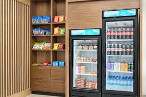 A vending machine stocked with snacks and beverages, including chips, popcorn, and sodas.