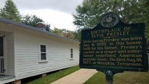 A historical marker sign for the birthplace of Elvis Presley, located in front of a white house with a porch. - American Inn  - Pontotoc (Pontotoc)