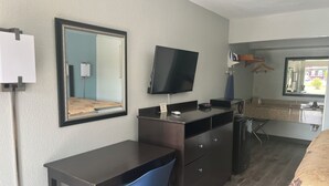 A hotel room with a desk, chair, TV, and a bed. - American Inn  - Pontotoc (Pontotoc)