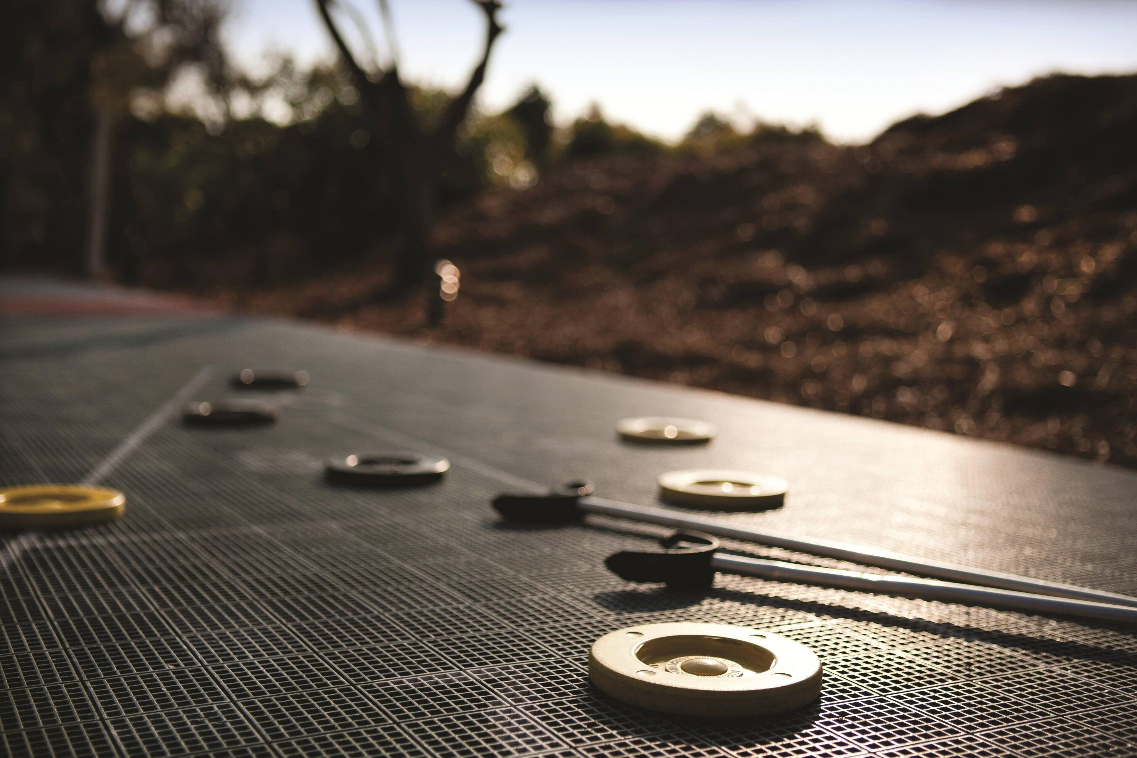 A close-up of a shuffleboard table with pucks and a cue stick.