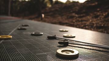 A close-up of a shuffleboard table with pucks and a cue stick.