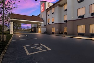 A hotel with a gas station, handicap parking, and a Red Roof Inn sign.