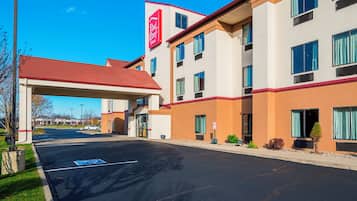 A hotel with a red roof, multiple windows, and a clear sky.
