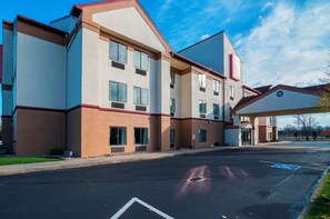 Ein mehrstöckiges Hotel mit Parkplatz davor.