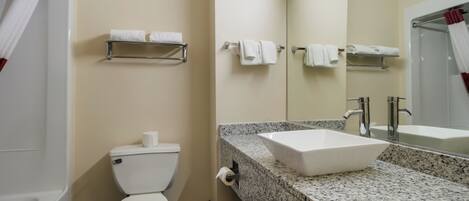 A bathroom with a toilet, a sink, and a mirror.