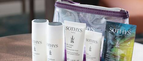 A collection of Sothys Paris skincare products including a cleansing milk, body lotion, and a sleeping mask, along with a cosmetic bag.