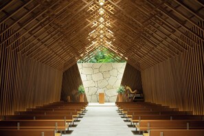 A church interior with wooden pews arranged in rows, a stone wall at the front, and a view of greenery outside. - The Westin Miyako Kyoto (Kyoto)