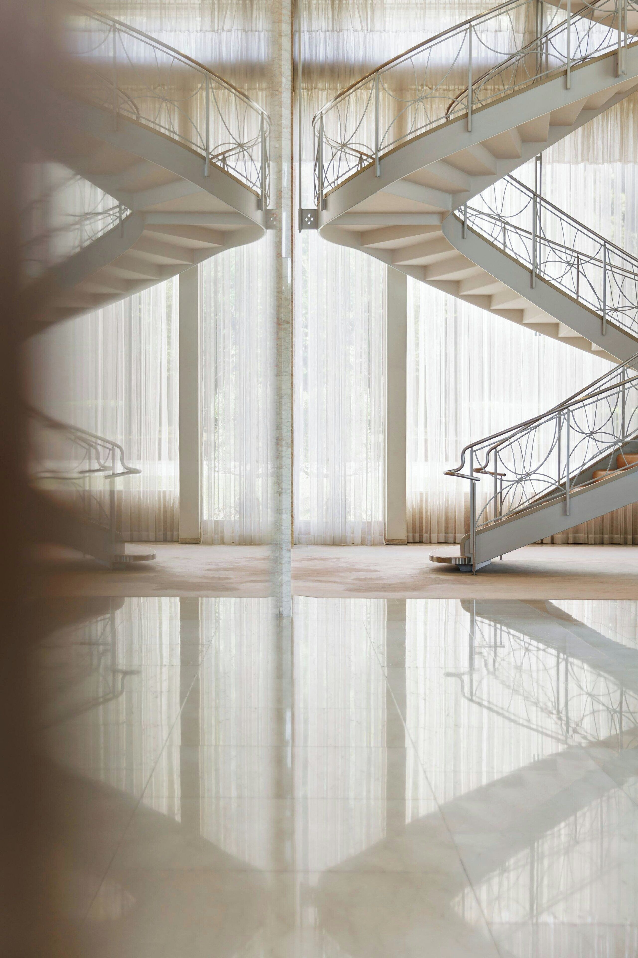 A spacious interior with a central staircase and large windows.