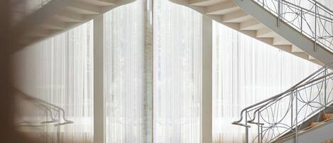A spacious interior with a central staircase and large windows.