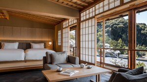 Una habitación tradicional japonesa con suelo de tatami, techo de madera bajo y amplios paneles de shoji.