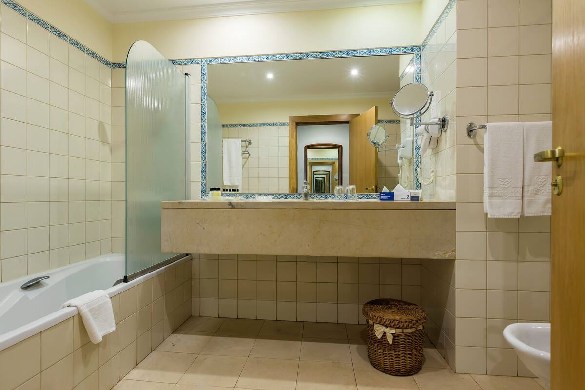 A bathroom with a bathtub, a sink, a mirror, and a shower.