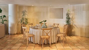 Un comedor con una mesa redonda dispuesta para cuatro personas, rodeada de sillas de madera.