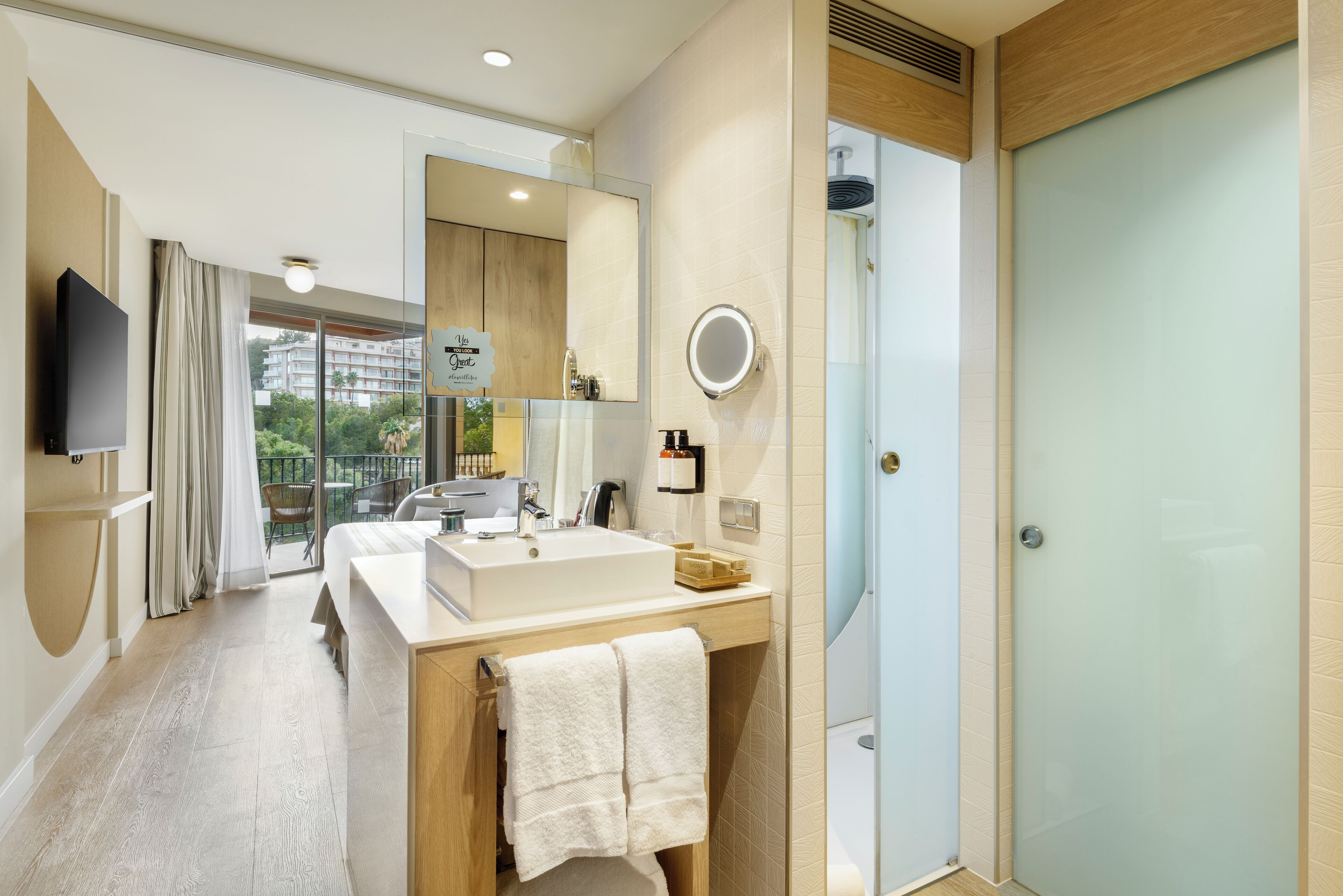 A modern bathroom with a large sink, mirror, and shower.