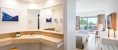 A modern bathroom with a curved sink, a wooden stool, and a large mirror.