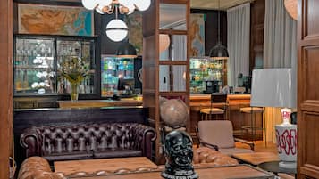 A bar area with leather seating, a globe, and a map on the wall.