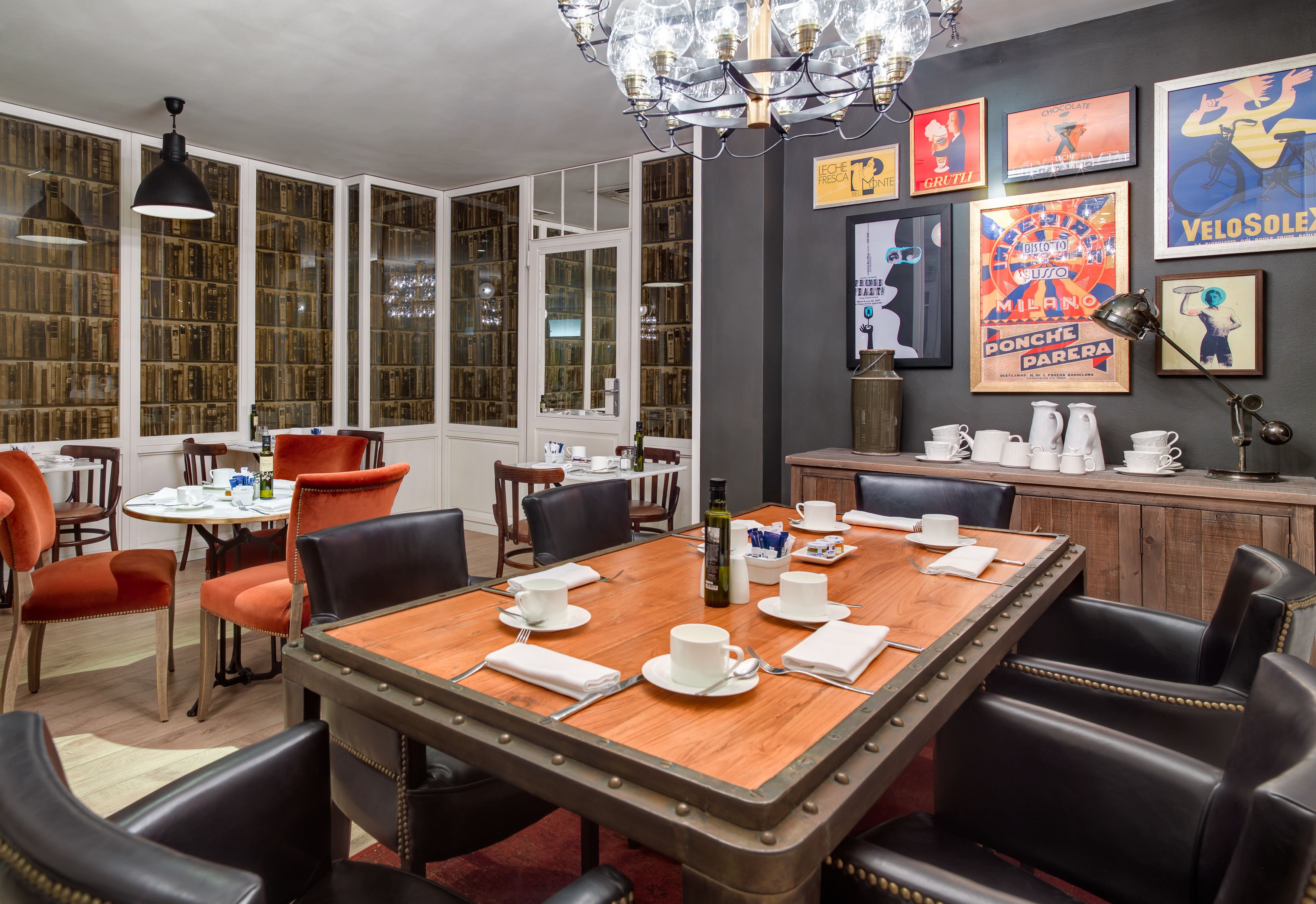 A dining area with a wooden table set for four, surrounded by leather chairs.