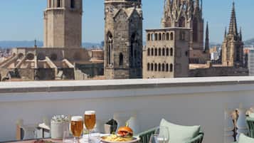 Mesa de comedor con comida y bebidas, con vistas a edificios históricos.
