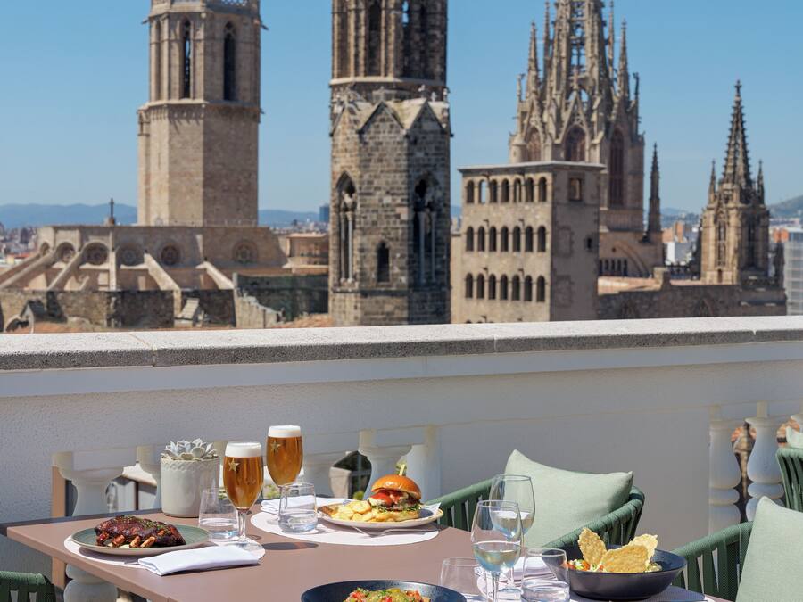A dining table with food and drinks, overlooking historic buildings.