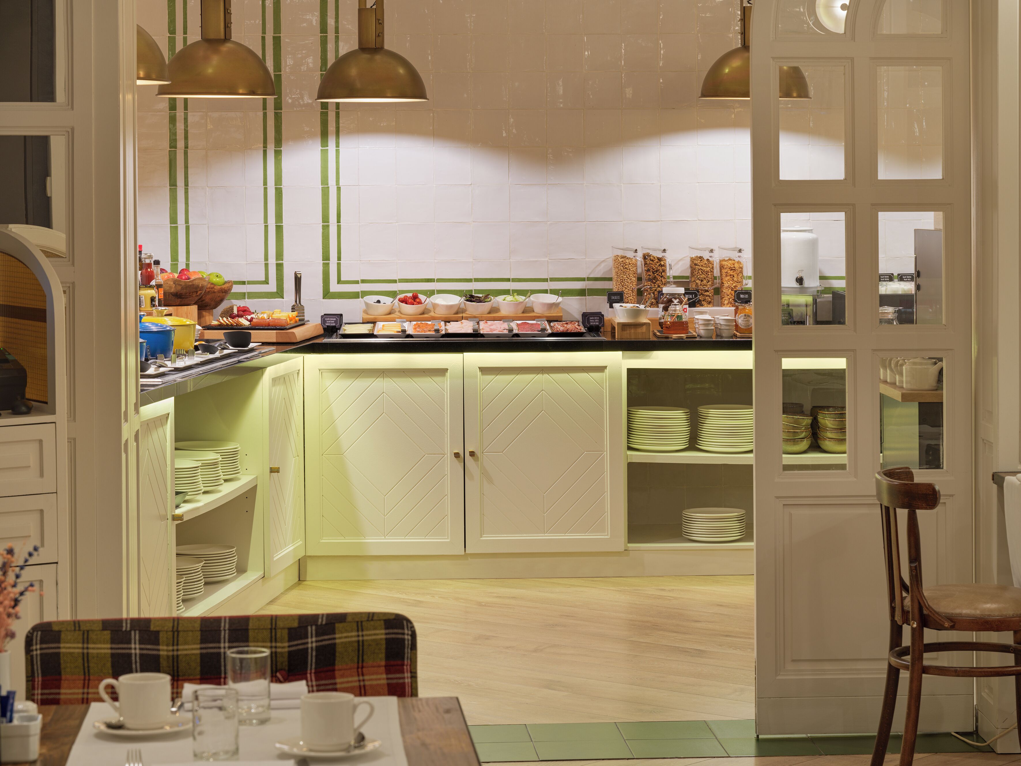 A breakfast buffet with various food items and a seating area with a plaid tablecloth.
