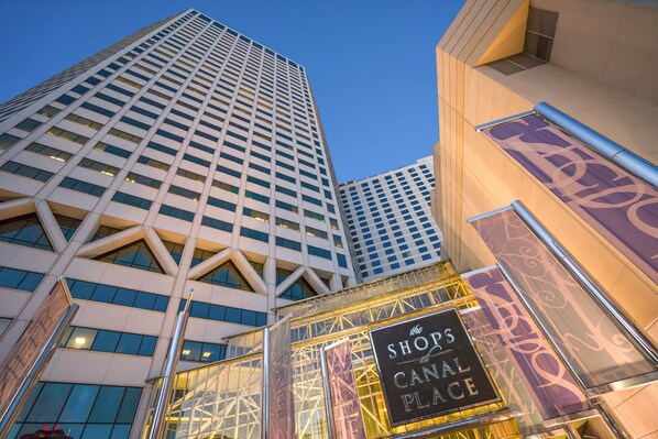 A modern building with a prominent sign for 'The Shops at Canal Place'.