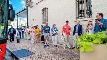 A group of people standing outside a building with a sign that reads "ONE 11".